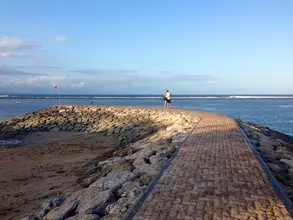 A person standing on the side of a pier.