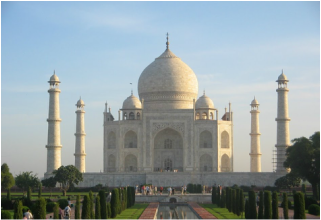 A white building with many pillars and bushes