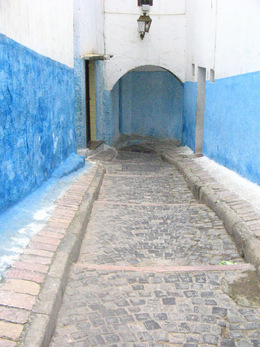 A blue and white wall with a brick walkway